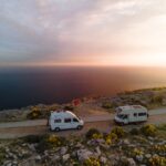 Two Camper standing on mountain in front of the ocean in Dubrovnik, Croatia. May, 2021.